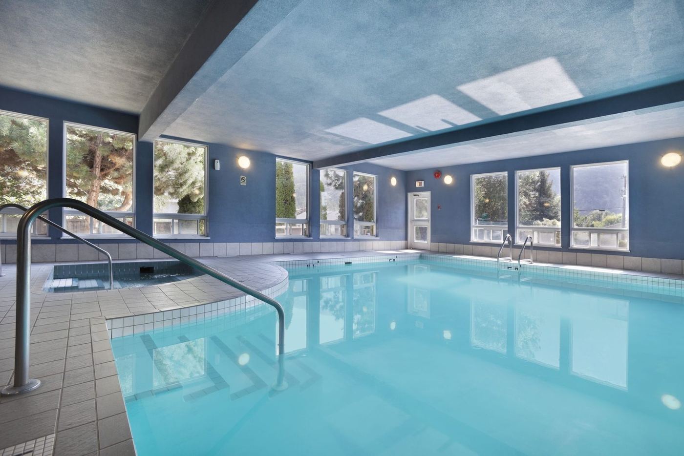 Indoor pool with skylights and poolside chairs